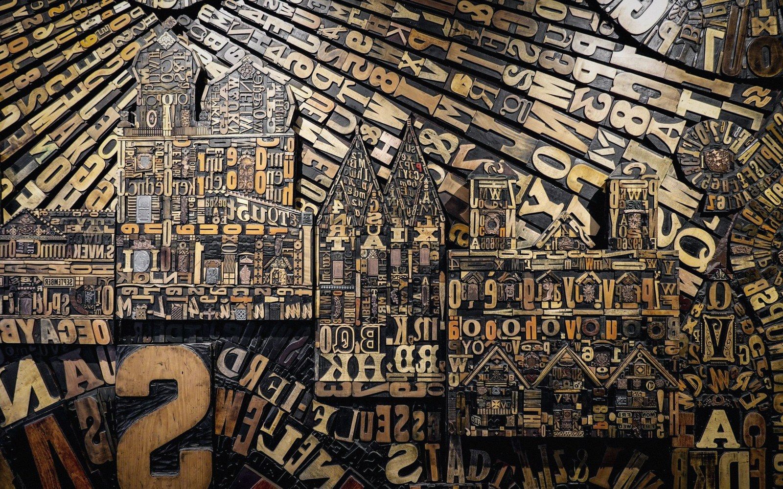 Wooden printing blocks and letterpress type arranged into a cityscape of gabled buildings